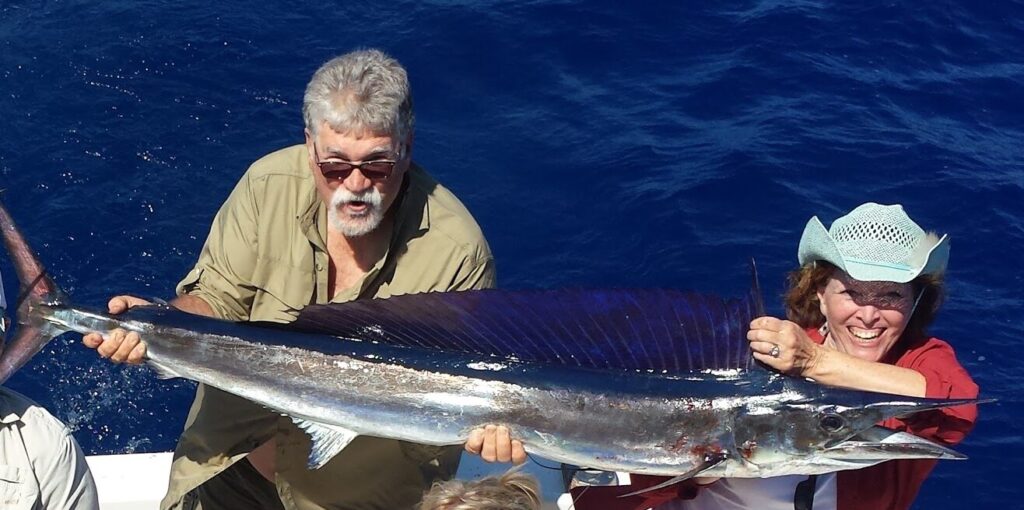 Fishing Tours Oahu Grand Slam Sportfishing Couple showcasing their trophy catch on a fishing trip.